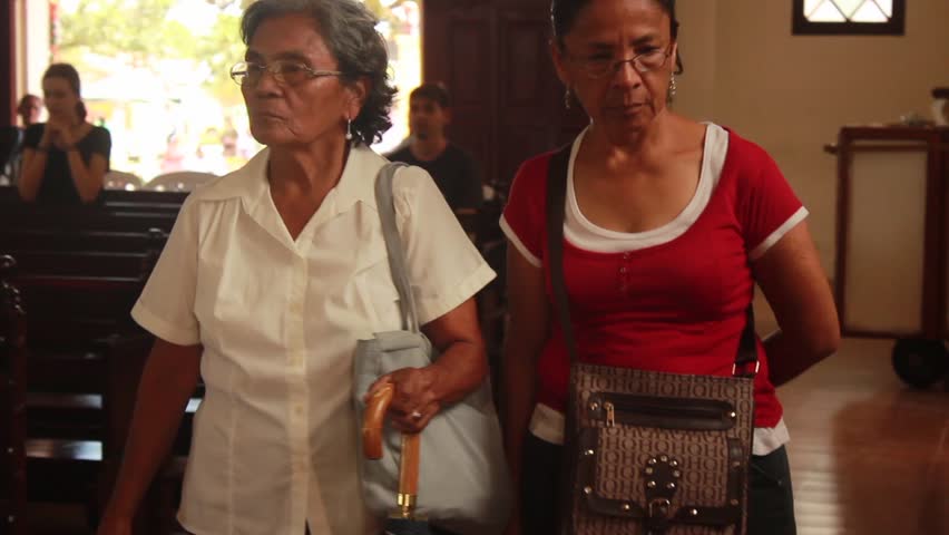Panama - March 18, 2018: Two Latina women walking inside a church in Central America