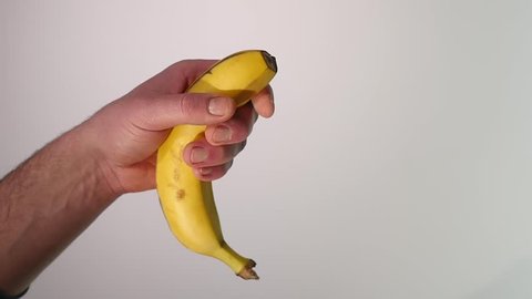 Vitamin and healthy eating. Ripe mellow banana fruit squeezed, mashed, or crushed with yellow skin and flesh drops, splashes, on white background