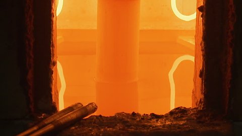 A close up shot of a orange glowing cauldron for melting glass 