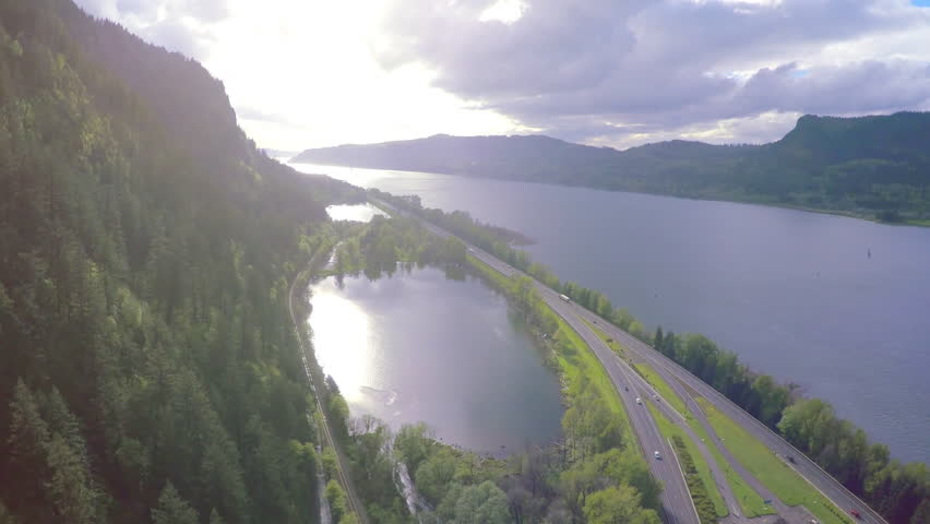 Helicopter view of sunset over the Columbia River Gorge, quick pan to waterfalls.