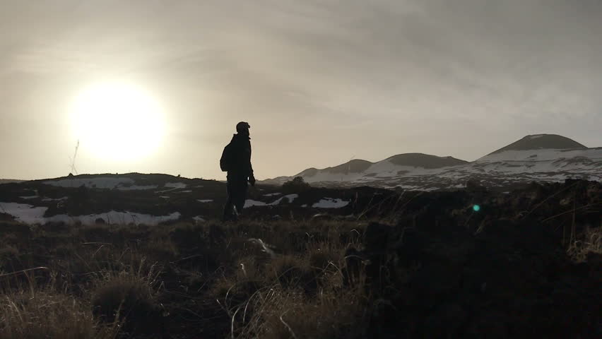 bearded man lost in the mountain environment he keep a small hammer in his hand 