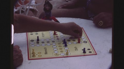 SPAIN, MALLORCA, JULY 1983. Five Shot Sequence Of Grandparents With A Happy Little Girl Playing A German Board Game Called Mensch Aergere Dich Nicht, At A Beach Bar