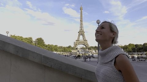 4K video of a young woman wandering in the streets of Paris near the Eiffel Tower, contemplating the view and enjoying travel. People cities traveling concept