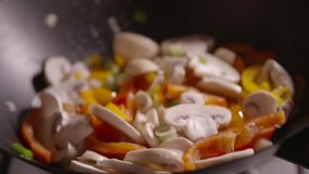 Slow motion clip featuring stir fry vegetables in a pan close up