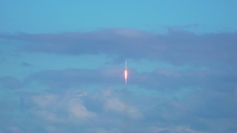 Space rocket lifting-off into space with exhaust flames and smoke. Beautiful clouds and sky. Wide-angle. 120 fps slow motion.
