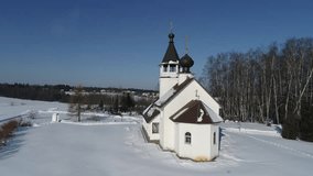 Aerial drone view video of The Church of the Smolensk icon of the Mother of God in the village Podolino, Moscow region, Russia. Russian winter landscape around