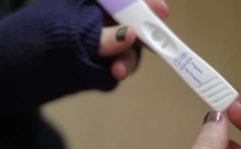 Young woman holding a pregnancy test