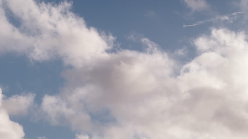 Clouds float by on a sunny day.