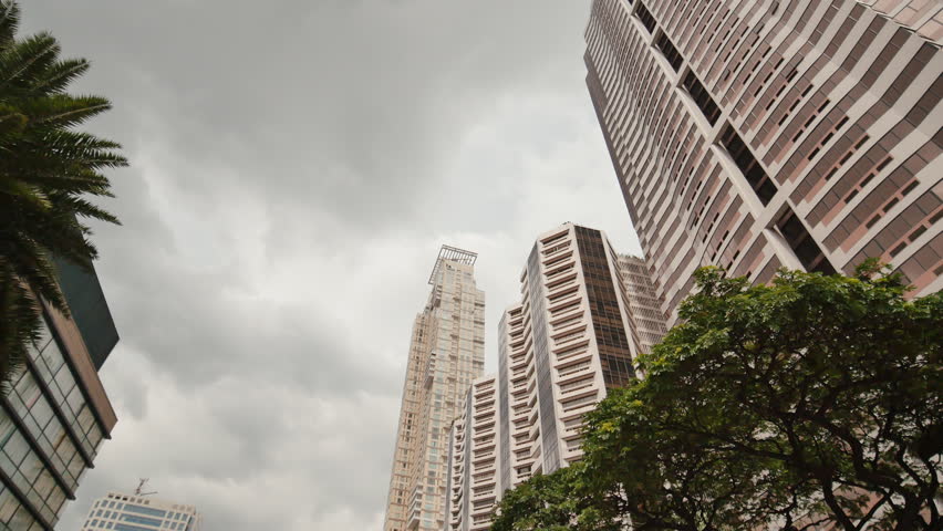 Skyscrapers against the backdrop of palm trees. Shooting in motion. Makati District in Manila. Philippines.