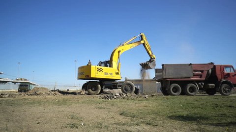 Volgograd, Russian Federation – September 25, 2017: Excavator loading soil from construction site of stadium Volgograd Arena into a dumper truck