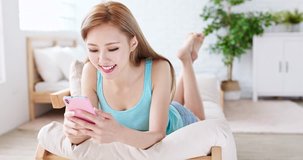 woman use phone happily and lying on sofa at home