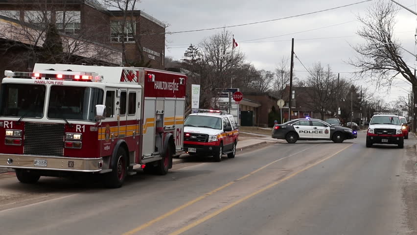 Fire truck, police cars and emergency response vehicles on scene of fire in the city. 