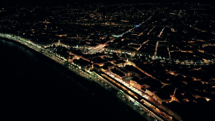 Night aerial view of illuminated Nice town in France. Flight over promenade.