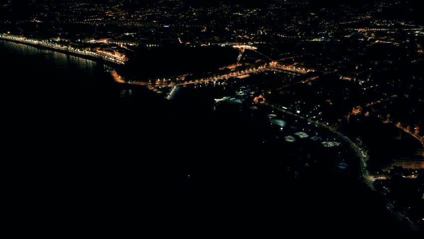 Night aerial view of illuminated Nice town in France. Flight over Nice marine port.
