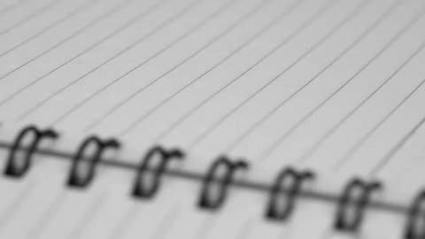 Open lined notepad with spiral binding in macro close up, dolly shot
