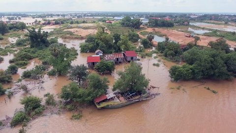Aerial drone shot ; fly over flooding along the river inundated rural houses and agricultural fields