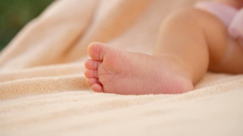 Soft focus, A close-up of tiny, little baby feet on light coverlet background