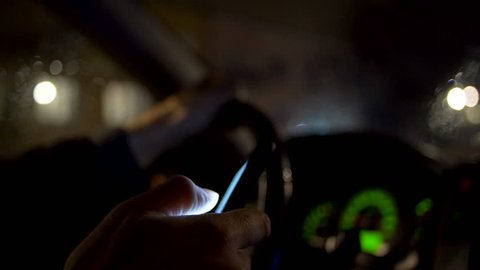 Using smartphone white driving at night in the city