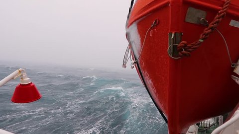 A storm in the ocean with big waves. View from the ship to the lifeboat. Storm in Drake passage