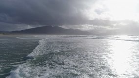Aerial Footage Of Waves And Mountain At Beach
