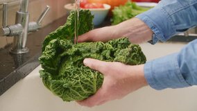 Man Hands Removing Leaves While Washing Savoy Cabbage In Sink