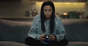 Close-up of a determined girl playing a video game with skill and expertise at home.