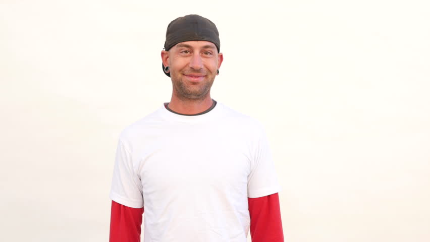 Guy with gauge earrings smilingl. White background.