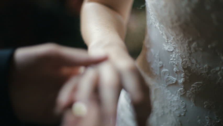 The groom puts the wedding ring on finger of the bride. marriage hands with rings. The bride and groom exchange wedding rings. | Shutterstock HD Video #1008927560