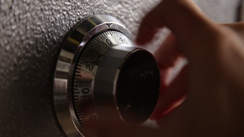 Locking and then opening a safe - close up on dial - combination lock of a safe or vintage bank steel vault used by a person or bank teller or robber breaking in and stealing money and jewelry  | Shutterstock HD Video #1008927635