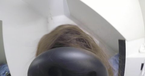 Casual woman with long brown hair drying hair with electric blowdryer. Dryer pov