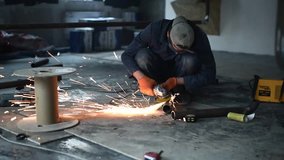 Welder at work in factory. Sparks during cutting of metal angle grinder