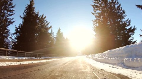 POV driving in the dazzling sun in a snowy winter forest
