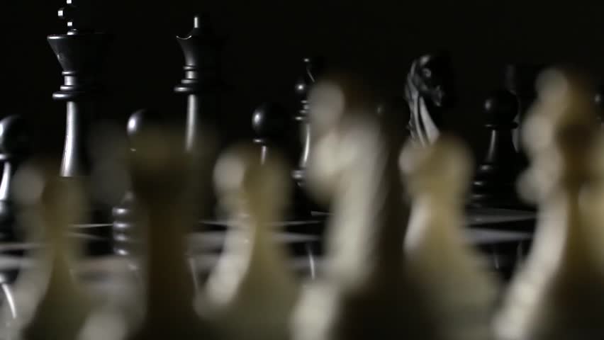 Slow tracking shot behind chess pieces on marble chess board Royalty-Free Stock Footage #1008965318
