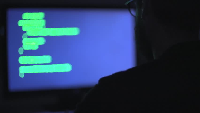 hacker as he sits at a computer screen Royalty-Free Stock Footage #1008965417