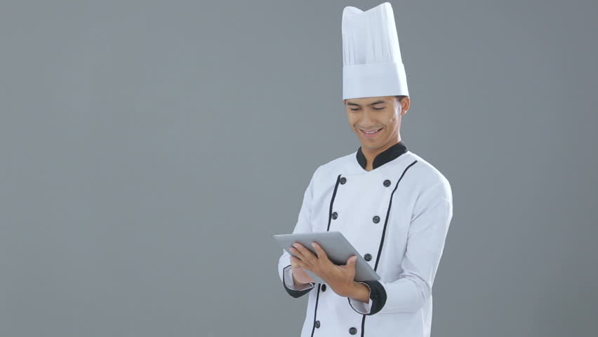 A busy chef with his tablet smiling to camera
