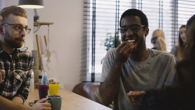 Creative team meeting in office with snacks. Startup partners. Casual mixed ethnicity colleagues group conversation. 4K. - Powered by Shutterstock - Get 15% off with code: PIKWIZARD15