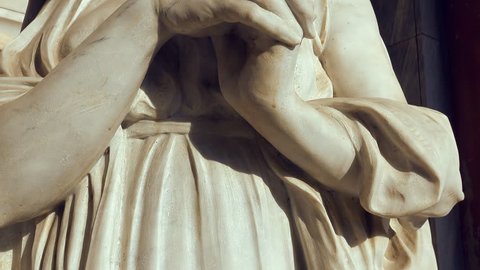 white marble statue of praying woman
