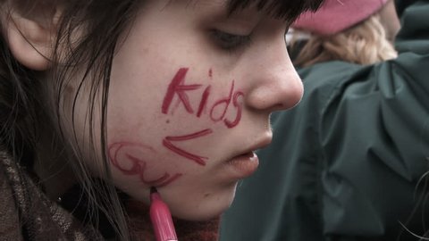 PORTLAND, OREGON / USA - MARCH 24, 2018: Girl writes on her face in protest to gun violence against kids at March For Our Lives.