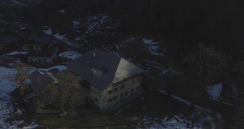 Establishing crane shot of a chalet in a serene French Alps in the morning