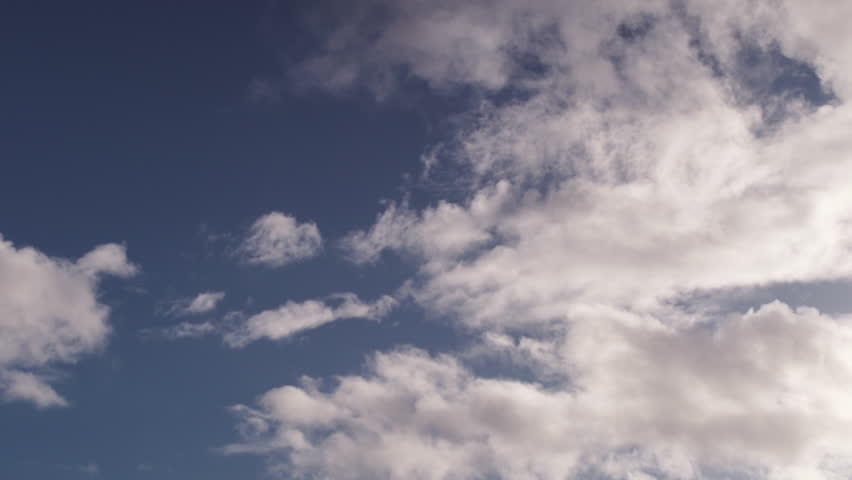 Clouds float by on a sunny day.