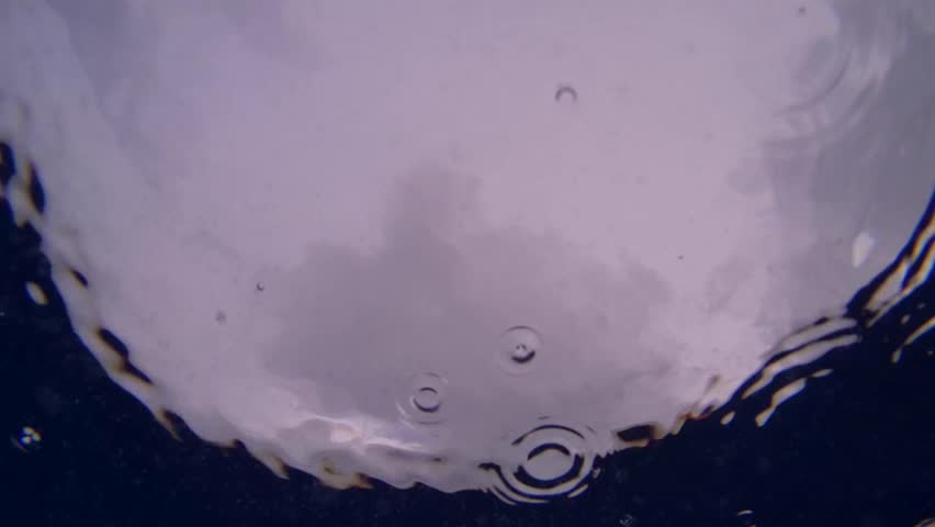 Scene of tropical rain in ocean, view from underwater 