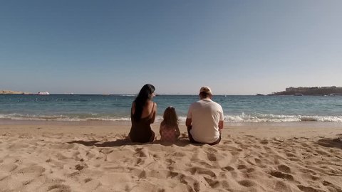 Happy family enjoying summer holiday on beach