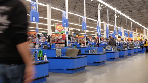 Port Coquitlam, BC, Canada - March 20, 2018 : Motion of people paying foods at check out counter inside Walmart store with 4k resolution