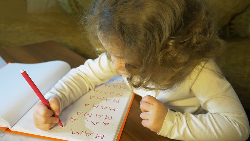 Little girl learns to write the word mama