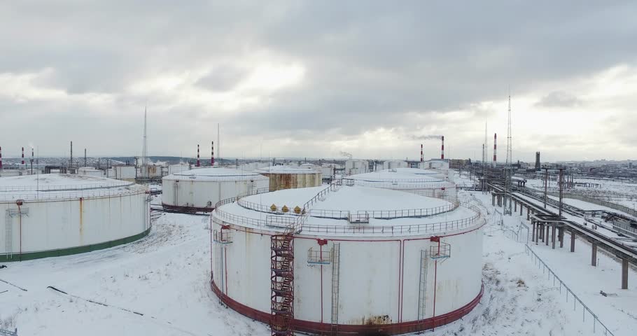 Giant white oil tanks in refinery in industrial zone on a winter cloudy day. Aerial view. Royalty-Free Stock Footage #1009005323