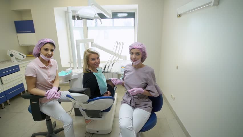 Patient, dentist doctor and assistant in dental clinic smiling | Shutterstock HD Video #1009017344