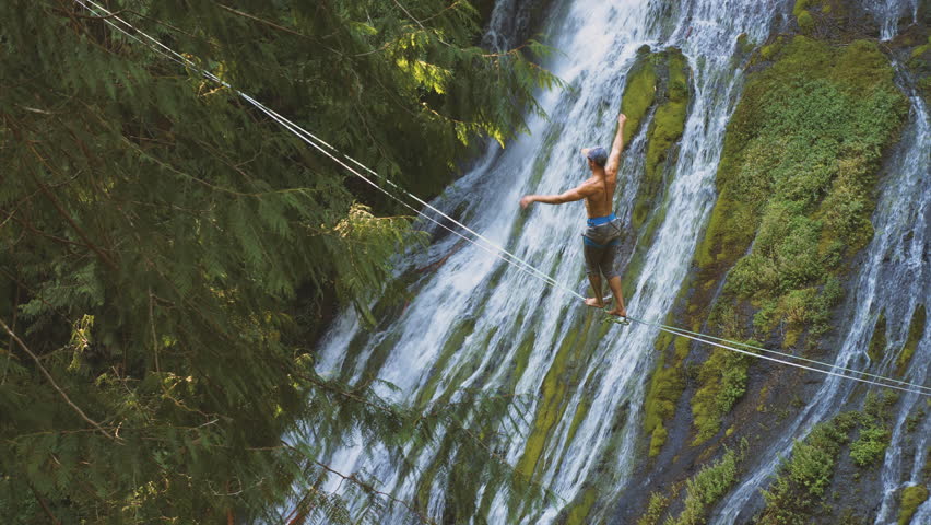 Fit Man Highlining Over A Waterfall In Oregon