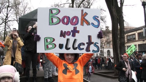 PORTLAND, OREGON / USA - MARCH 24, 2018: Little boy holds sign reading "Books, Not Bullets" joining in the March For Our Lives protesting gun violence and school shootings.
