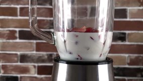 Mixing smoothie in blender with strawberries and milk, super slow motion video