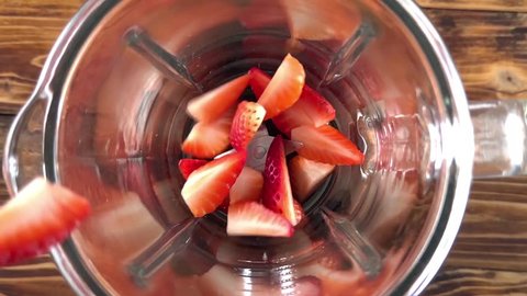 Fresh ripe strawberries pouring in a blender, super slow motion video